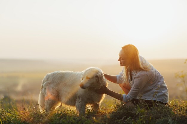 mulher curtindo um pôr do sol de verão com seu cachorro