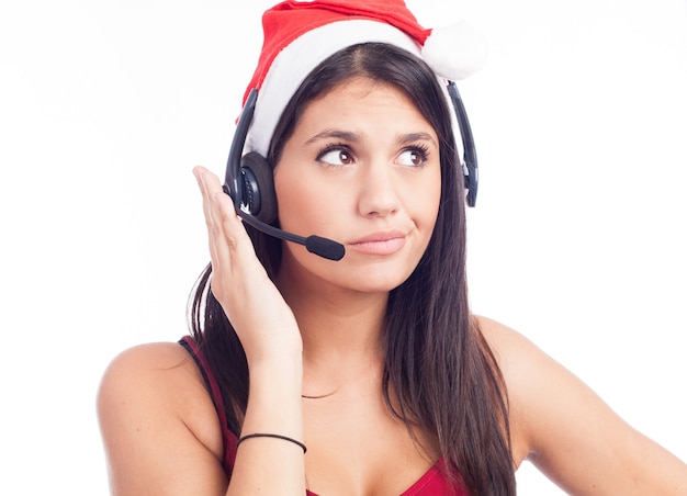 Mulher da central de atendimento de telemarketing usando chapéu de papai noel vermelho falando sorrindo isolado na parede branca