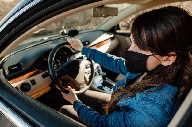 Mulher da máscara médica no carro.