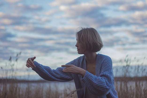 Foto mulher dançando contra o céu nublado