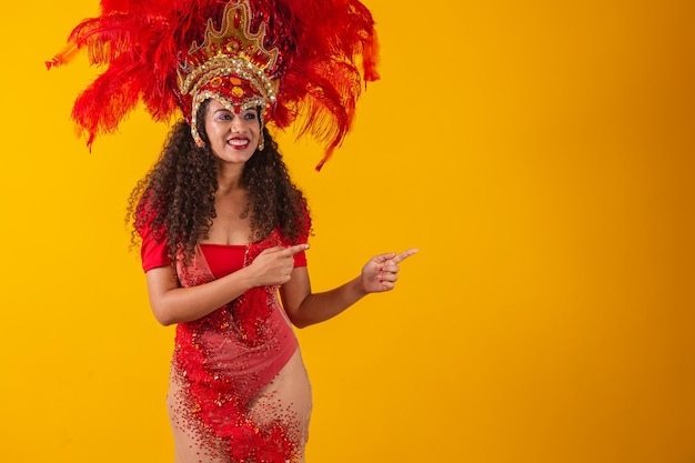 Mulher dançarina de carnaval apontando para o lado.