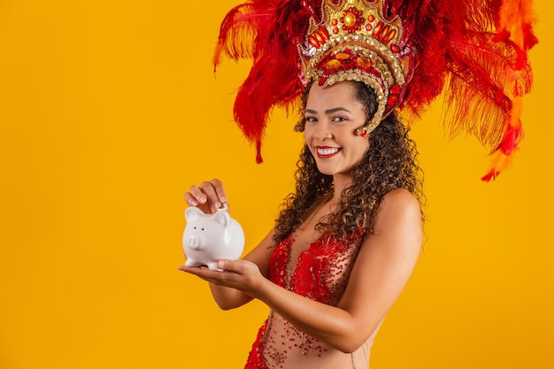 Mulher dançarina de carnaval segurando um cofrinho nas mãos. conceito de poupar para o carnaval