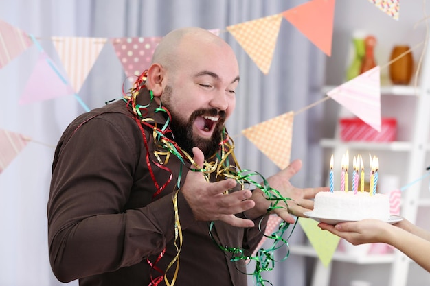 Mulher dando bolo de aniversário para gordo engraçado na festa