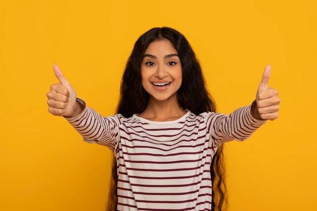 Foto mulher dando polegar em fundo amarelo