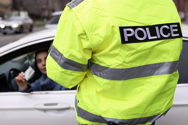 Mulher dando suborno a policial fora da janela do carro fechada