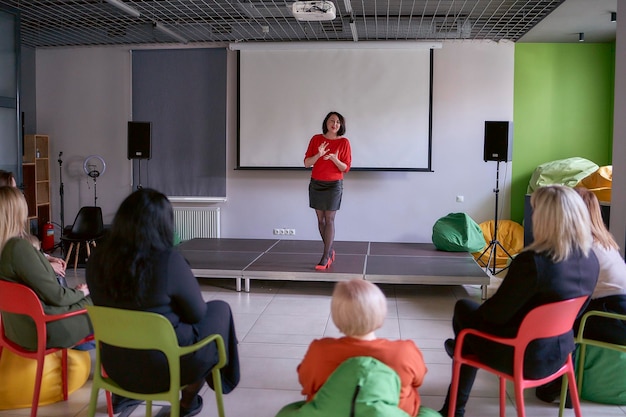 mulher dando um discurso emocional no palco do salão de apresentação no escritório