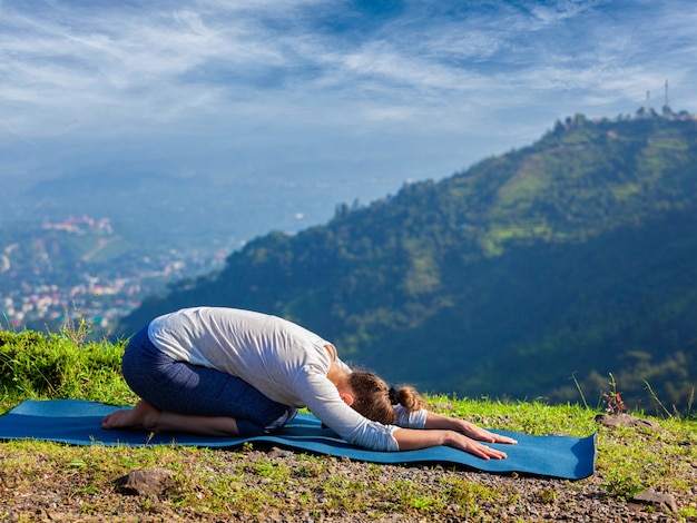 Mulher de ajuste desportivo pratica ioga asana Balasana