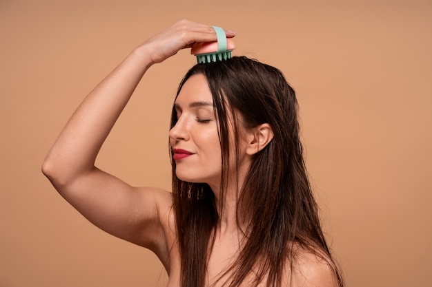Foto mulher de altura média a dar-se uma massagem no couro cabeludo.