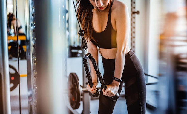 Foto mulher de aptidão fazendo exercícios cross fit bodybuilder no ginásio corpo musculoso de fitness na rotina matinal treino de ginásio de fitness e conceitos de estilo de vida saudável