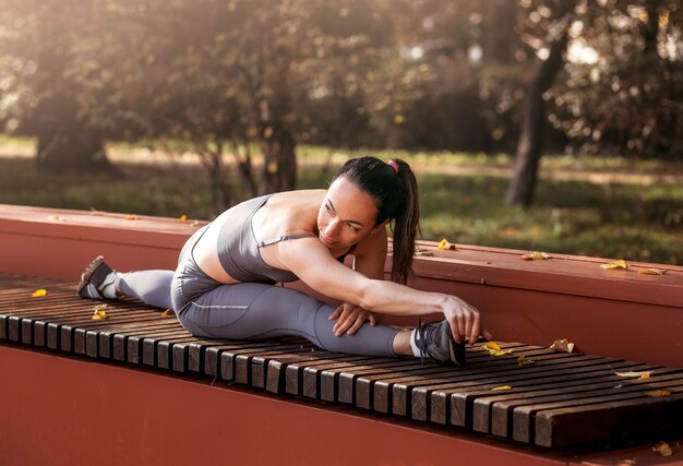 Mulher de aptidão fazendo exercícios de ioga estendendo-se no parque de verão Esporte conceito saudável