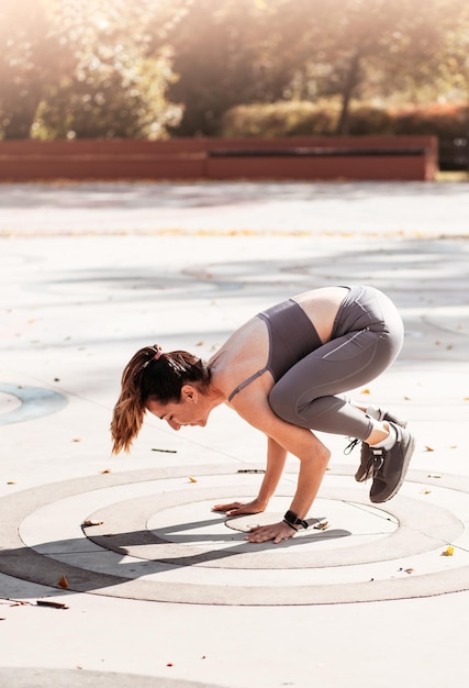 Mulher de aptidão fazendo exercícios de ioga estendendo-se no parque de verão Esporte conceito saudável