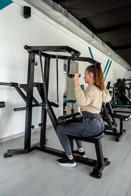Mulher de aptidão muscular fazendo exercícios para aumentar os músculos do corpo Fisiculturista de conceito de estilo de vida saudável no ginásio