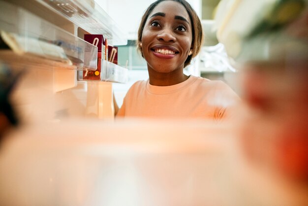 Foto mulher de ascendência africana abrir a geladeira