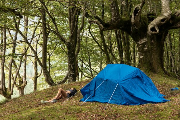 Mulher de aventura de caminhada explora as montanhas e encontra a serenidade no acampamento