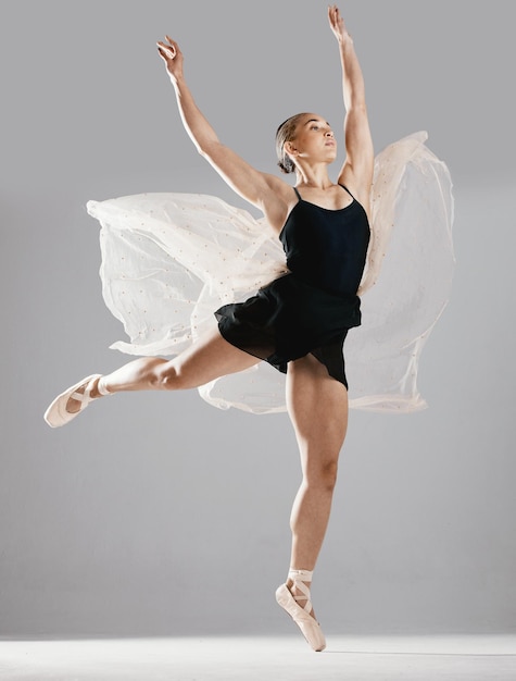 Mulher de balé ou dançarina com treinamento de pose ou performance em fundo de estúdio branco Bailarina ou artista feminina com alongamento técnico para um show ou arte elegante com criatividade ou fitness