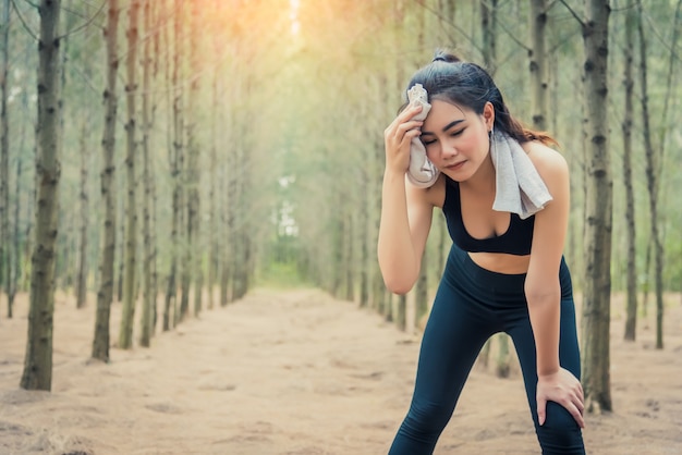 Mulher de beleza asiática, limpando o suor na floresta