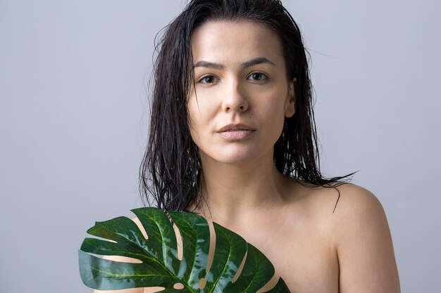 Mulher de beleza com retrato em folha de palmeira verde natural. Moda, beleza, maquiagem, cosméticos.