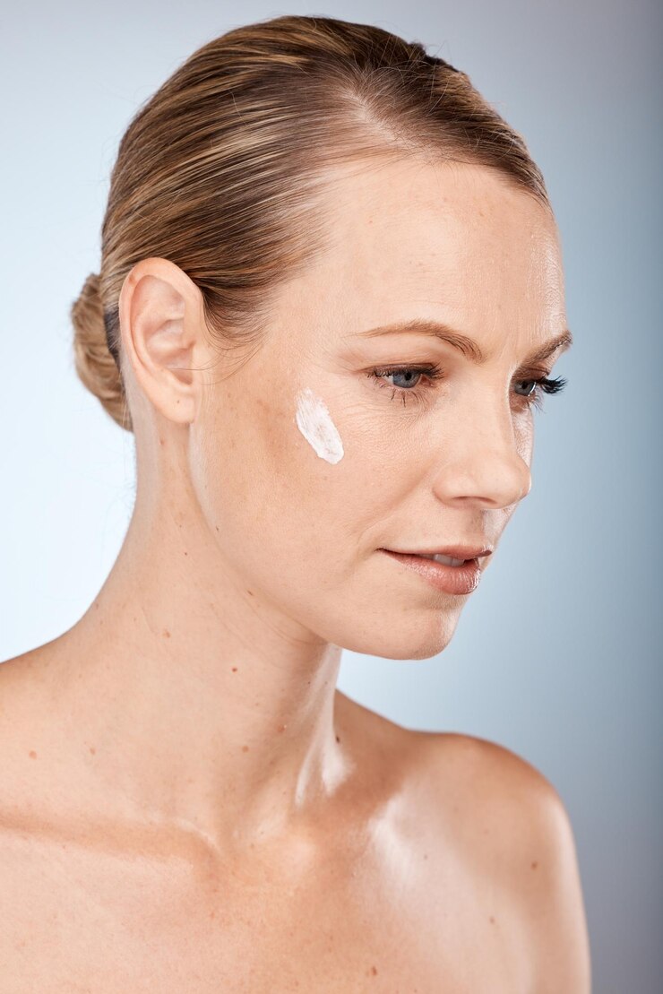 Foto mulher de beleza e pensando com creme para a pele no rosto para cuidados com o corpo, saúde e tratamento cosmético protetor solar natural e modelo de cosméticos de bem-estar com ideia sobre creme para a pele no estúdio cinza