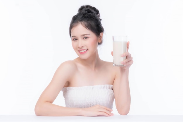 Mulher de beleza Linda garota asiática se sente feliz bebendo leite para uma boa saúde pela manhã no conceito de mulher de beleza estilo de vida de fundo branco