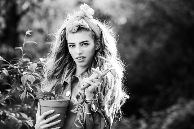 Mulher de beleza passa tempo no pomar mulher plantando flores em vaso