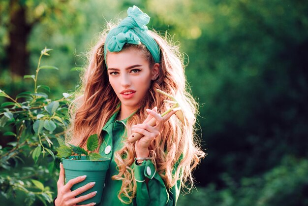 Mulher de beleza passa tempo no pomar mulher plantando flores em vaso