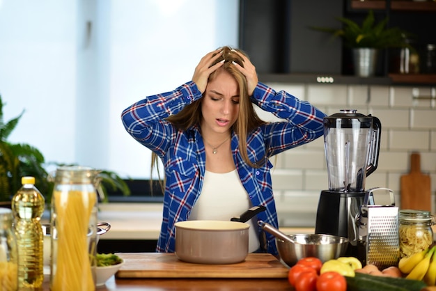 Mulher de beleza se sente confusa na cozinha