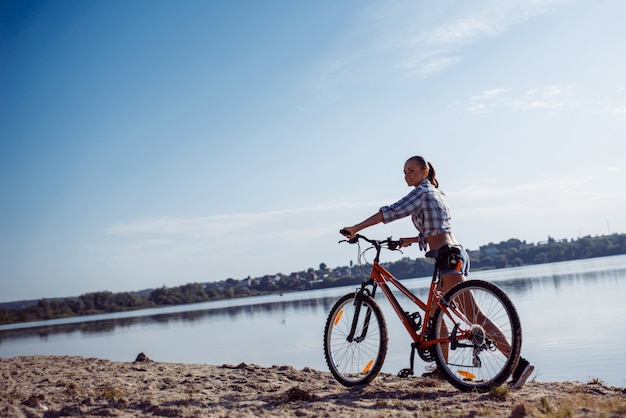 Mulher de bicicleta na praia