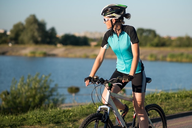 Mulher de bicicleta no fundo da água do lago no parque