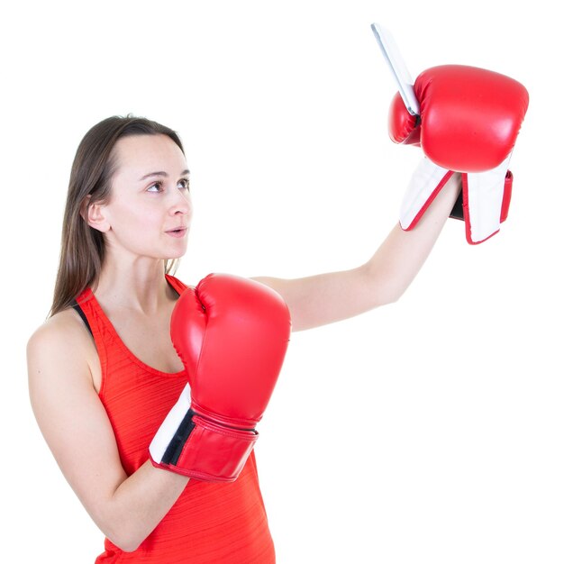 Mulher de boxe fitness posando isolada sobre fundo branco tira uma selfie pelo celular com luvas vermelhas