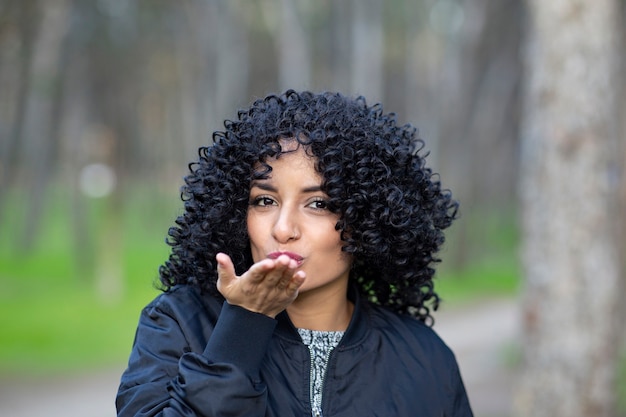 Mulher de cabelo afro mandando um beijinho