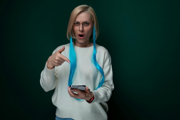 Mulher de cabelo azul segurando um celular