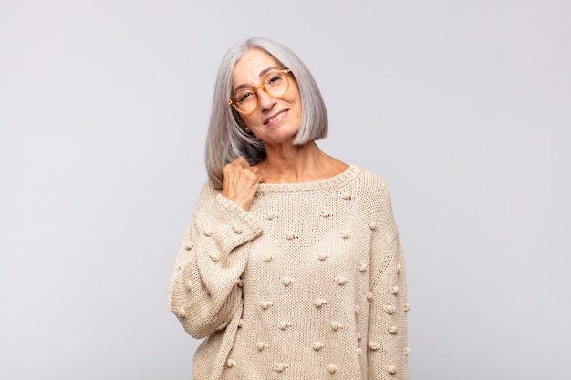 Mulher de cabelo grisalho rindo alegre e confiante