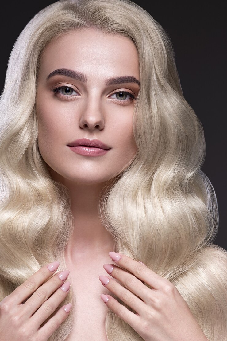 Foto mulher de cabelo loiro penteado encaracolado bonito cabelo comprido ondulado natural maquiagem. tiro do estúdio. em preto