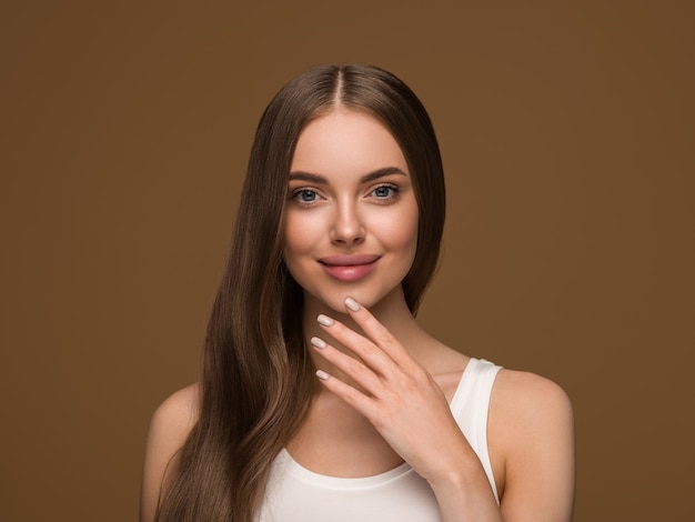 Mulher de cabelo longa e saudável com retrato de rosto de pele de beleza de cabelo longo encaracolado. Cor de fundo marrom