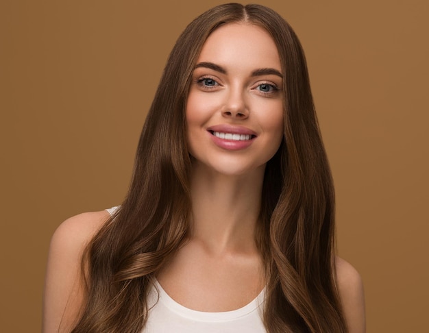 Mulher de cabelo longo e saudável com retrato de rosto de pele de beleza de cabelo longo encaracolado. Cor de fundo marrom