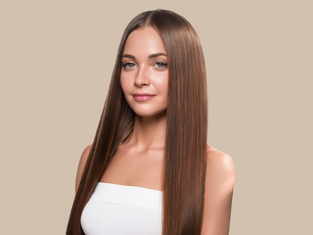 Mulher de cabelo longo liso bonito feliz pele limpa cor de fundo. Marrom.