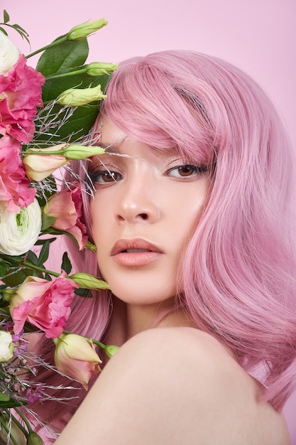 Mulher de cabelo rosa segurando um buquê de flores