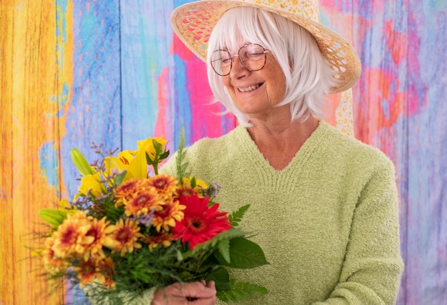 mulher de cabelos brancos sênior segurando um buquê de flores da primavera dia da mulher dia dos namorados