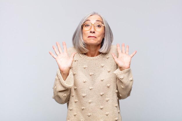 Mulher de cabelos grisalhos parecendo nervosa, ansiosa e preocupada, dizendo que não é minha culpa