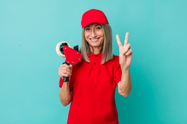 Mulher de cabelos grisalhos sênior sorrindo e parecendo amigável, mostrando o conceito de funcionário do empacotador número dois