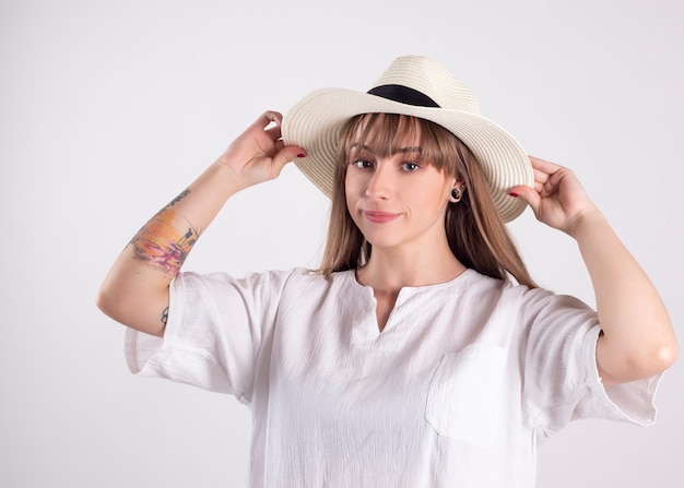 Mulher de camisa branca e chapéu