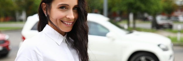 Foto mulher de camisa branca fica na rua e sorri. emoções positivas todos os dias conceito.