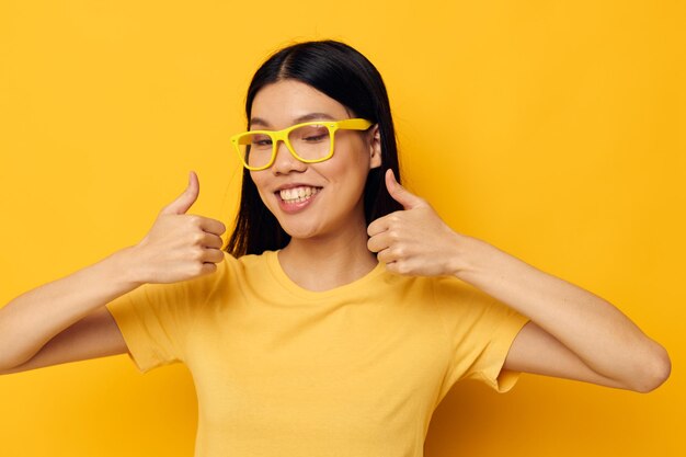 Mulher de camiseta amarela com óculos posando estilo de vida inalterado