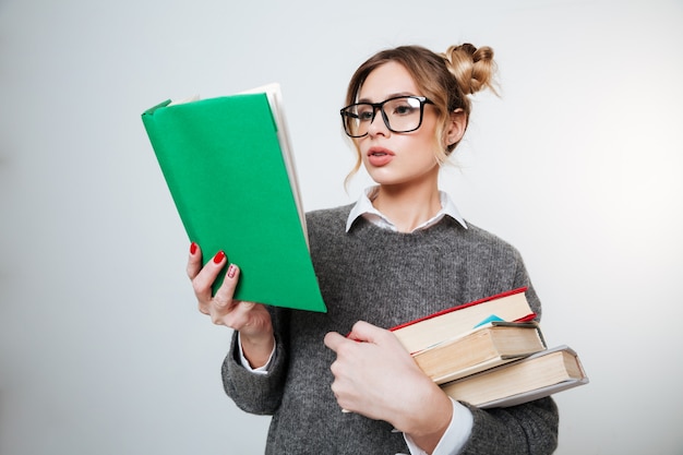 Mulher de camisola e óculos com livros