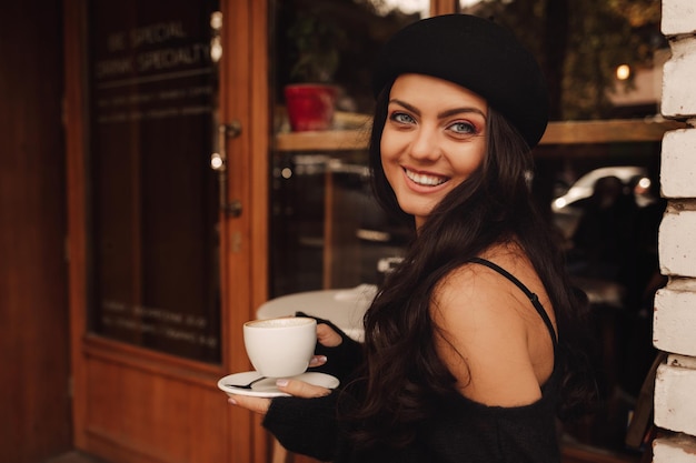 Mulher de chapéu com uma xícara de café