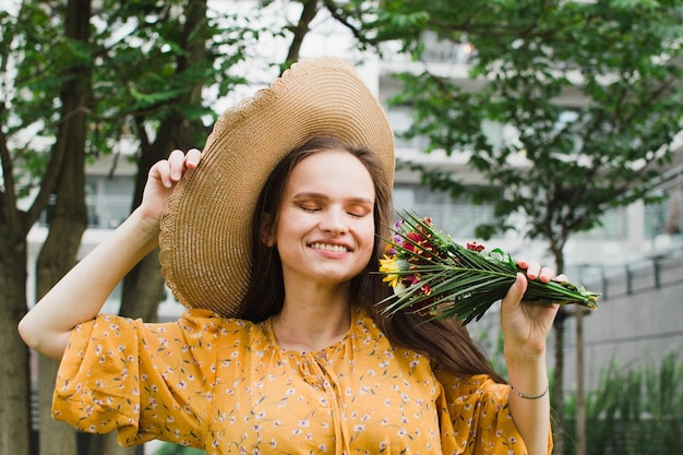 Mulher de chapéu de palha com um buquê