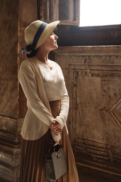 Foto mulher de chapéu em frente a uma janela do museu hagia sophia. istambul