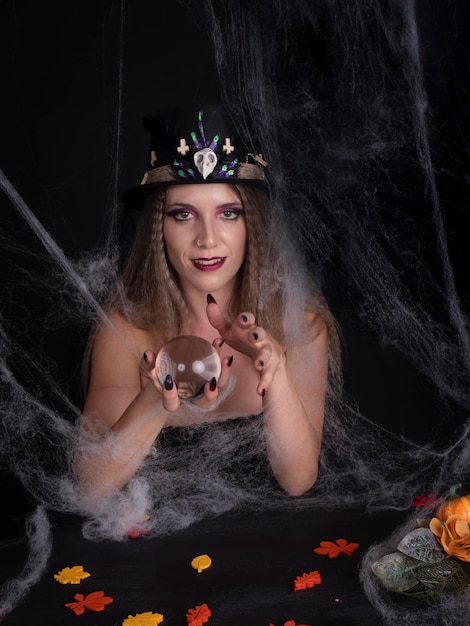 Foto mulher de chapéu fazendo mágica com bola de cristal