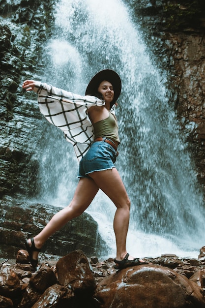 Mulher de chapéu marrom, apreciando a vista da cachoeira