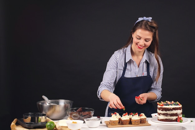 Mulher de chef de pastelaria decorar um bolo em um fundo isolado